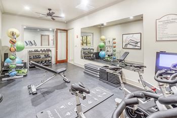 A gym with exercise equipment and a tv